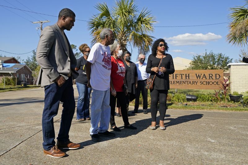 EPA Administrator Michael Regan, left, arrives at the Fifth Ward Elementary School, which is near the Denka plant, with Robert Taylor, second left, founder of Concerned Citizens of St. John's Parish, and Lydia Gerard, third left, a member of the group, in Reserve, La., Nov. 16, 2021.