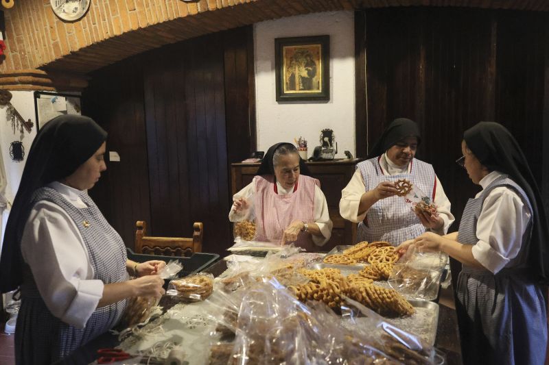 From left, nuns Alejandra Jaime, 39, Maria Ines Maldonado, 76, Maria Auxiliadora Estrada, 59, and Patricia Marin, 28, store fritters with Christmas figures in clear plastic bags for sale at the Convent of the Mothers Perpetual Adorers of the Blessed Sacrament in Mexico City, Dec. 7.