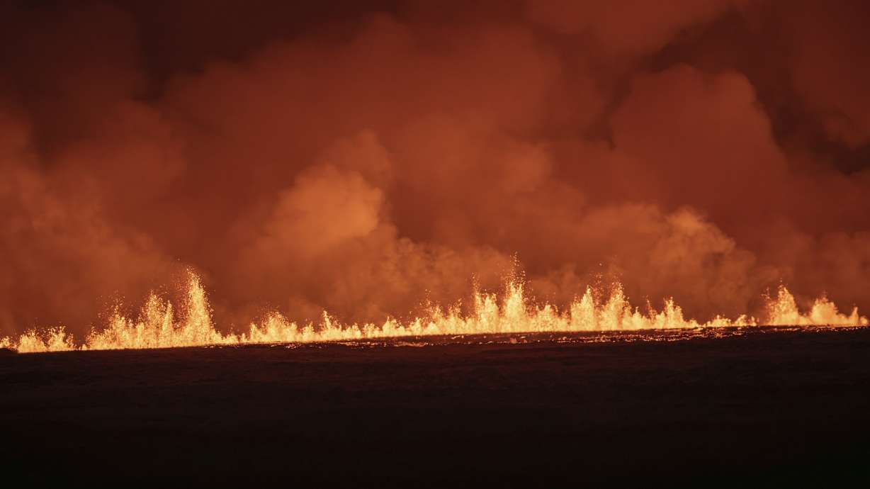 Lava fountains are seen as volcanic eruption started, turning the sky orange, in Grindavik on Iceland's Reykjanes Peninsula, Monday.