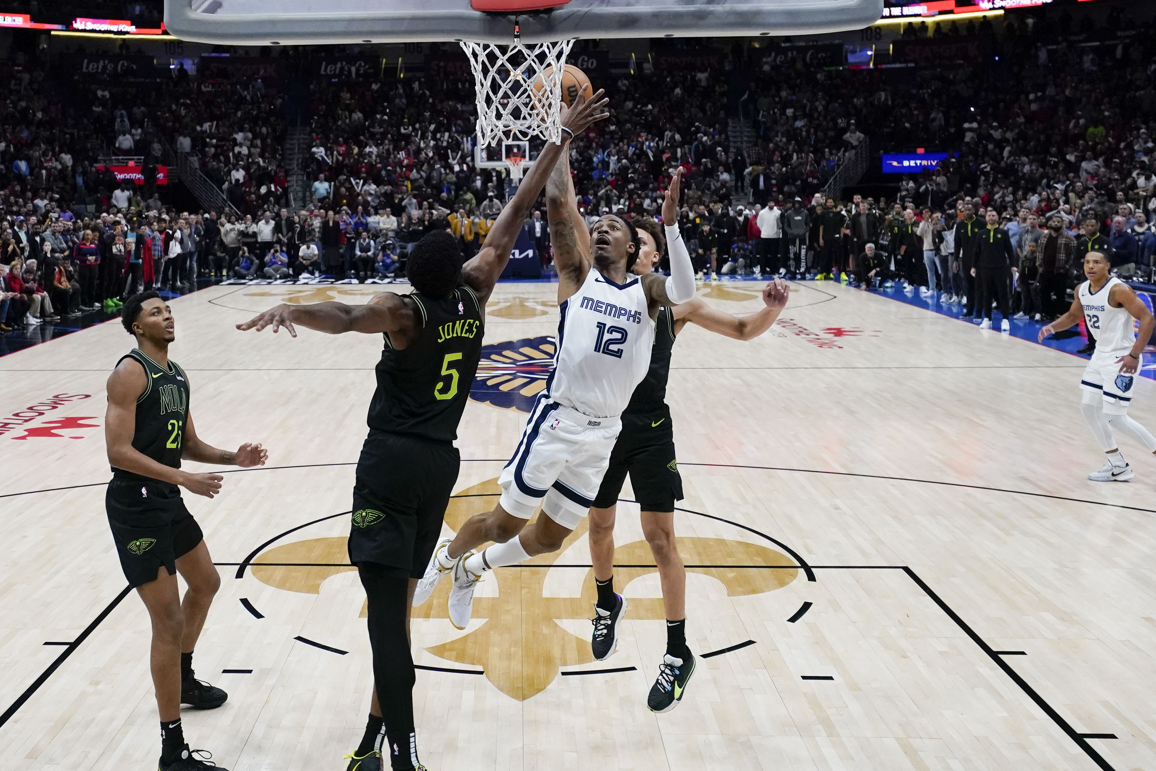 Memphis Grizzlies guard Ja Morant (12) goes to the basket between New Orleans Pelicans forward Herbert Jones (5) and guard Dyson Daniels for the game winning shot at the buzzer in the second half of an NBA basketball game in New Orleans, Tuesday, Dec. 19, 2023. The Grizzlies won 115-113. 