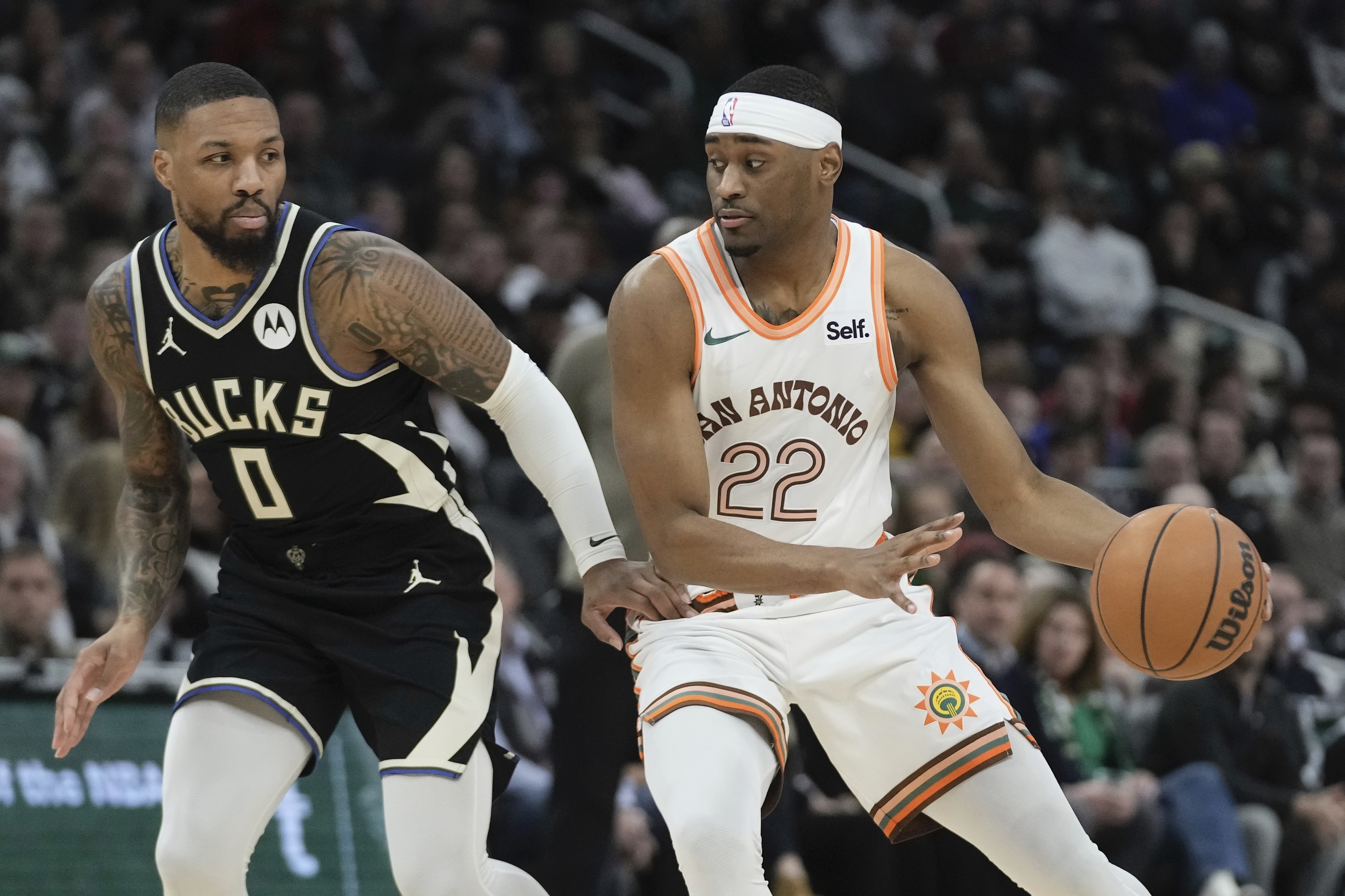 San Antonio Spurs' Malaki Branham tries to get past Milwaukee Bucks' Damian Lillard during the first half of an NBA basketball game Tuesday, Dec. 19, 2023, in Milwaukee.