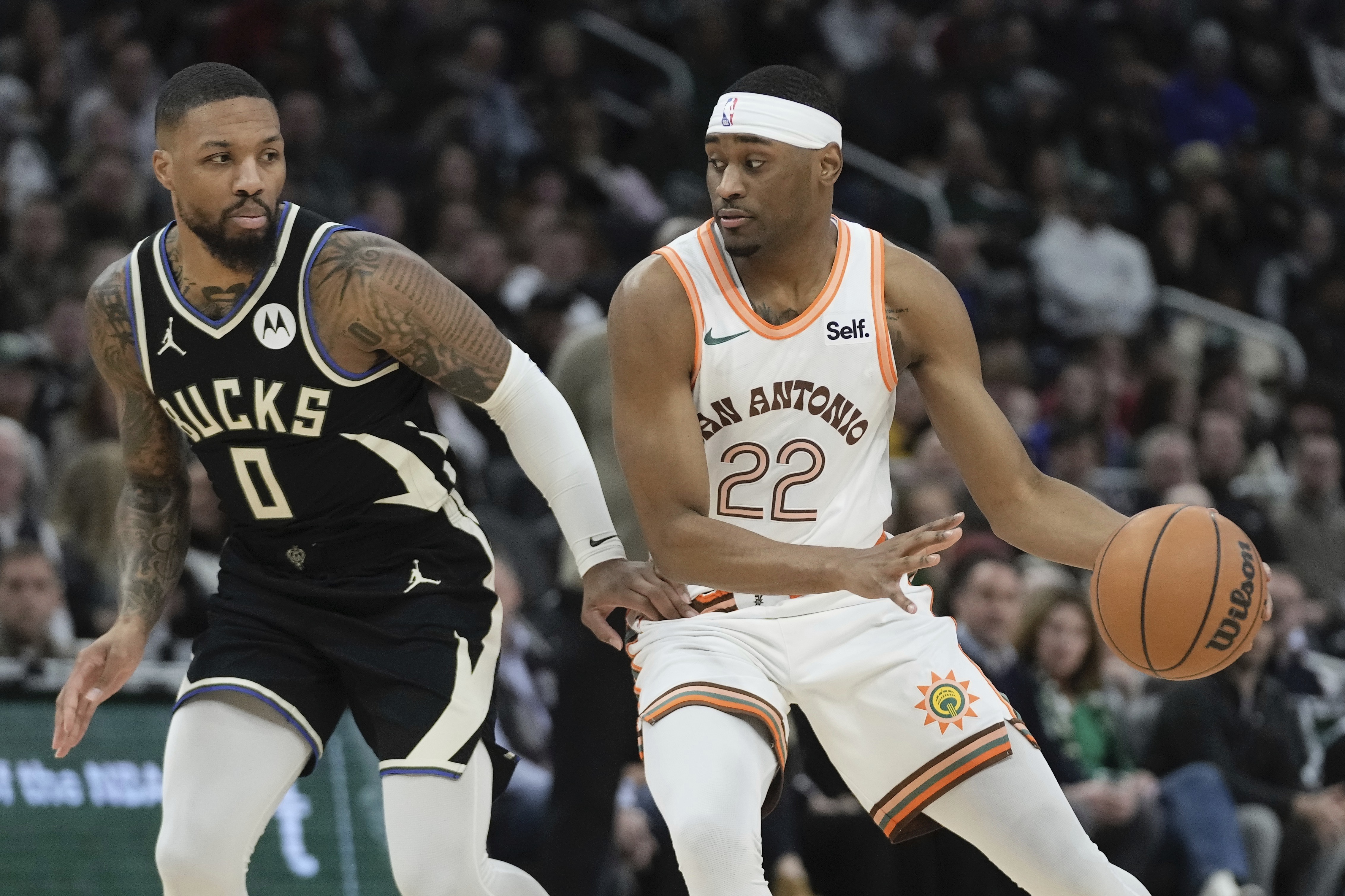 San Antonio Spurs' Malaki Branham tries to get past Milwaukee Bucks' Damian Lillard during the first half of an NBA basketball game Tuesday, Dec. 19, 2023, in Milwaukee. 