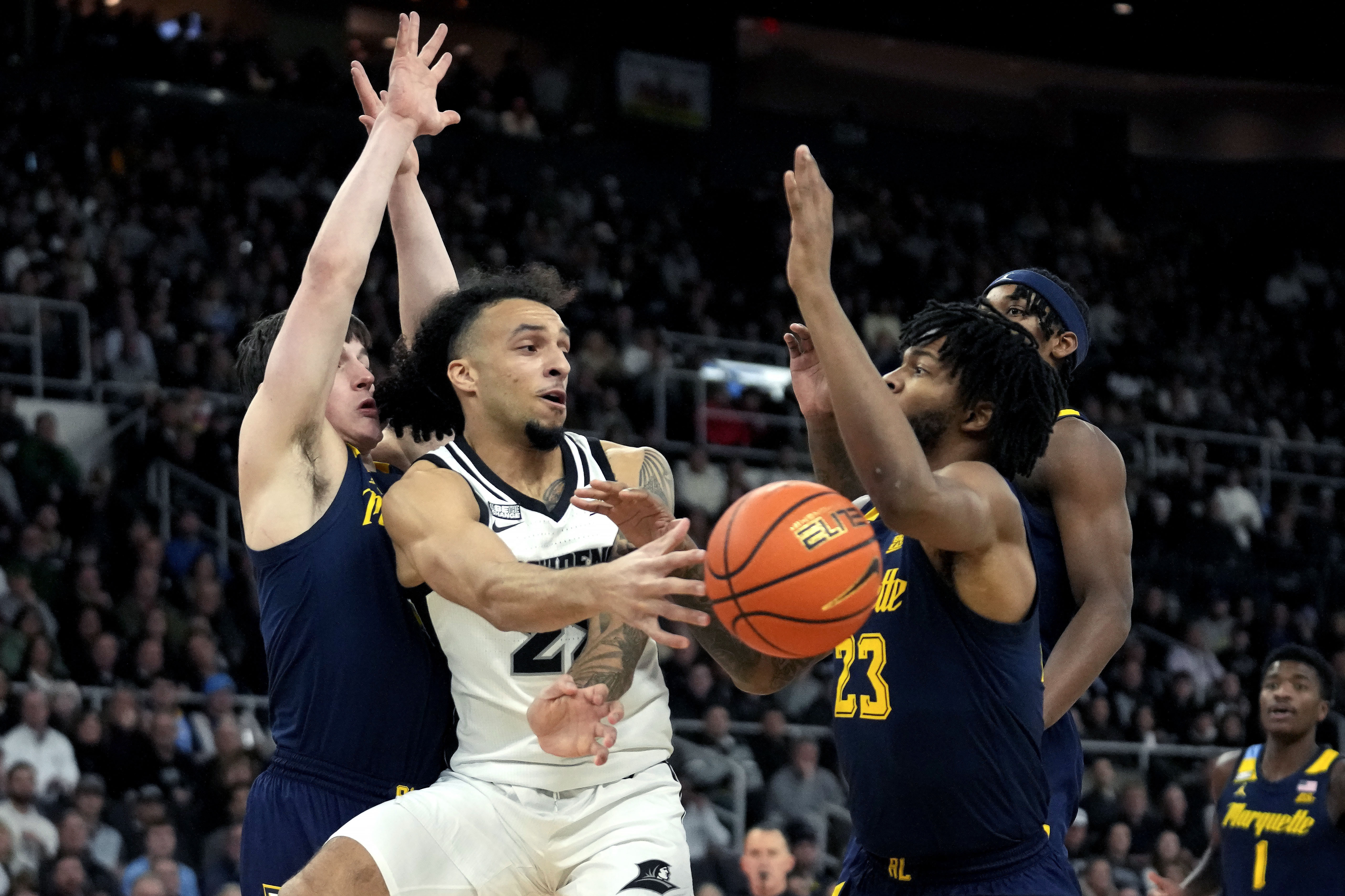 Providence guard Devin Carter (22), center, passes under pressure from Marquette guard Tyler Kolek, left, and forward David Joplin (23) during the first half of an NCAA college basketball game Tuesday, Dec. 19, 2023, in Providence, R.I. 