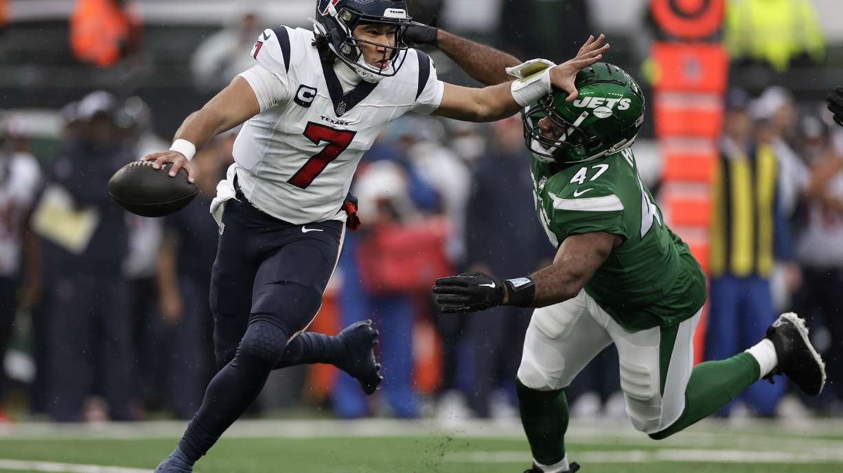Houston Texans quarterback C.J. Stroud (7) rolls out of the pocket under pressure from New York Jets linebacker Bryce Huff (47) during the first quarter of an NFL football game, Sunday, Dec. 10, 2023, in East Rutherford, N.J.