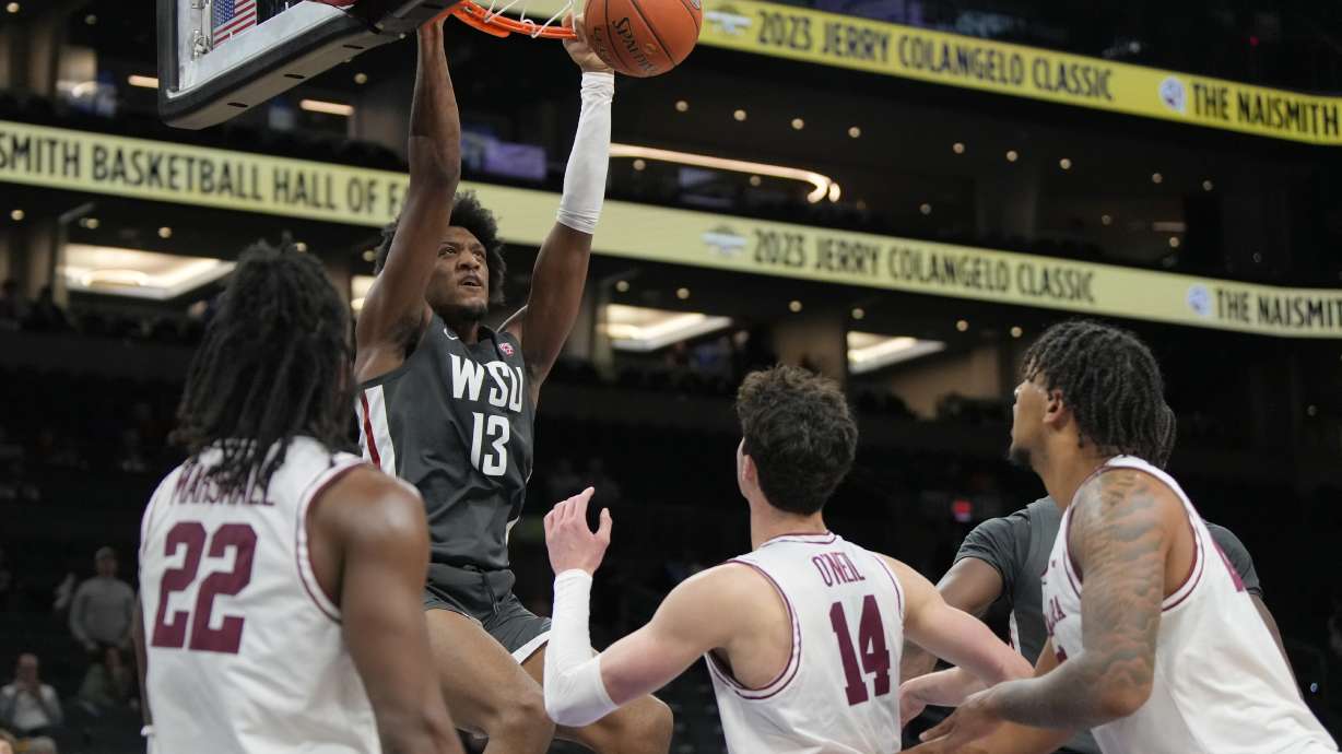 Washington State forward Isaac Jones (13) dunks over Santa Clara guard Carlos Marshall Jr. (22) and forward Johnny O'Neil (14) during the second half of an NCAA college basketball game, Saturday, Dec. 16, 2023, in Phoenix. Santa Clara won 69-61.