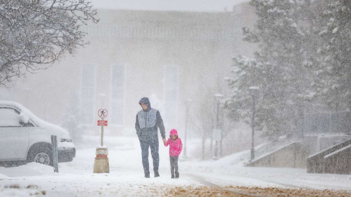Brock Peery and his daughter Berkley, 6, walk back to their car during a snowstorm in Salt Lake City on March 24. A new study led by University of Utah researchers offers new insight into how and why snowflakes fall the way they do.