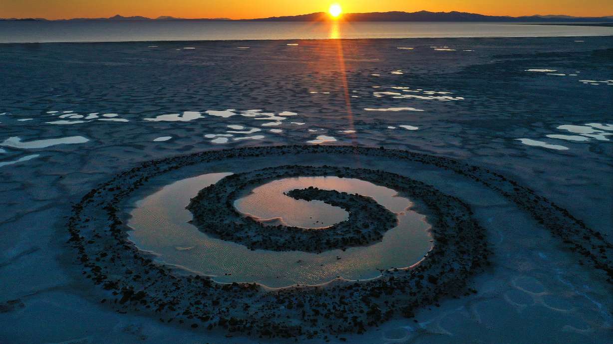 The sun sets on the Spiral Jetty on the Great Salt Lake on Thursday, March 16, 2023.