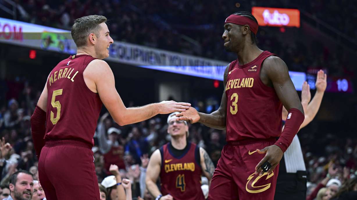 Cleveland Cavaliers guard Sam Merrill, left, is congratulated by guard Caris LeVert after a 3-point basket against the Utah Jazz during the first half of an NBA basketball game Wednesday, Dec. 20, 2023, in Cleveland.