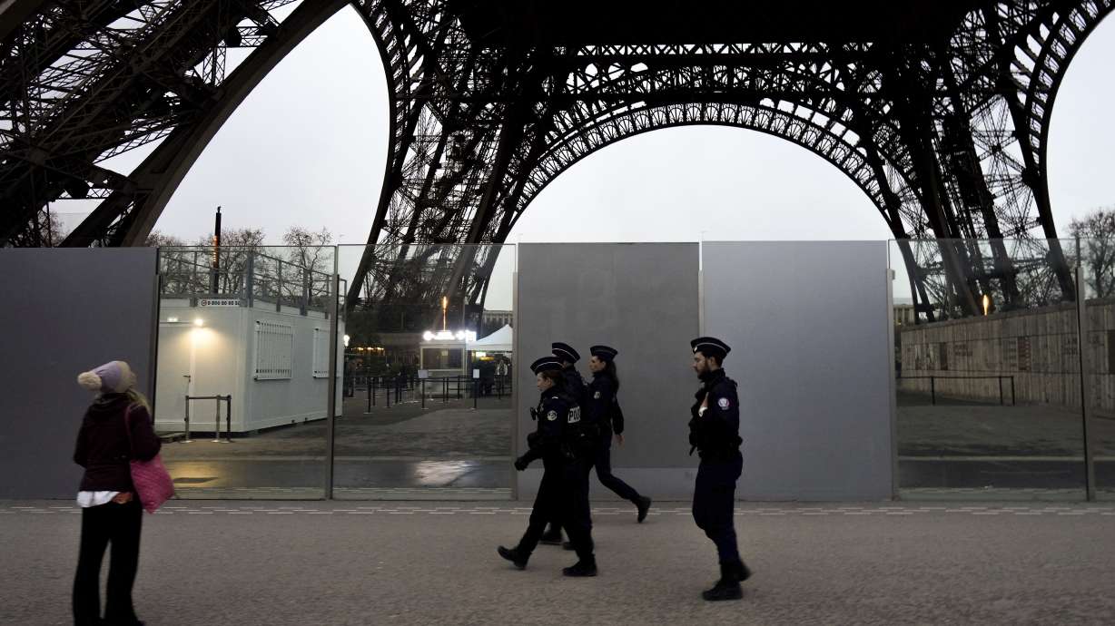 FILE - French policemen patrol near the Eiffel Tower, in Paris, Thursday, Dec. 7, 2023. The giant opening ceremony extravaganza that Paris is planning to hold on the River Seine to launch next year's Olympic Games could be moved if France is hit again in the run-up by extremist attacks, French President Emmanuel Macron said Wednesday Dec.21, 2023. The security, with tens of thousands of police and soldiers deployed, will be intense.