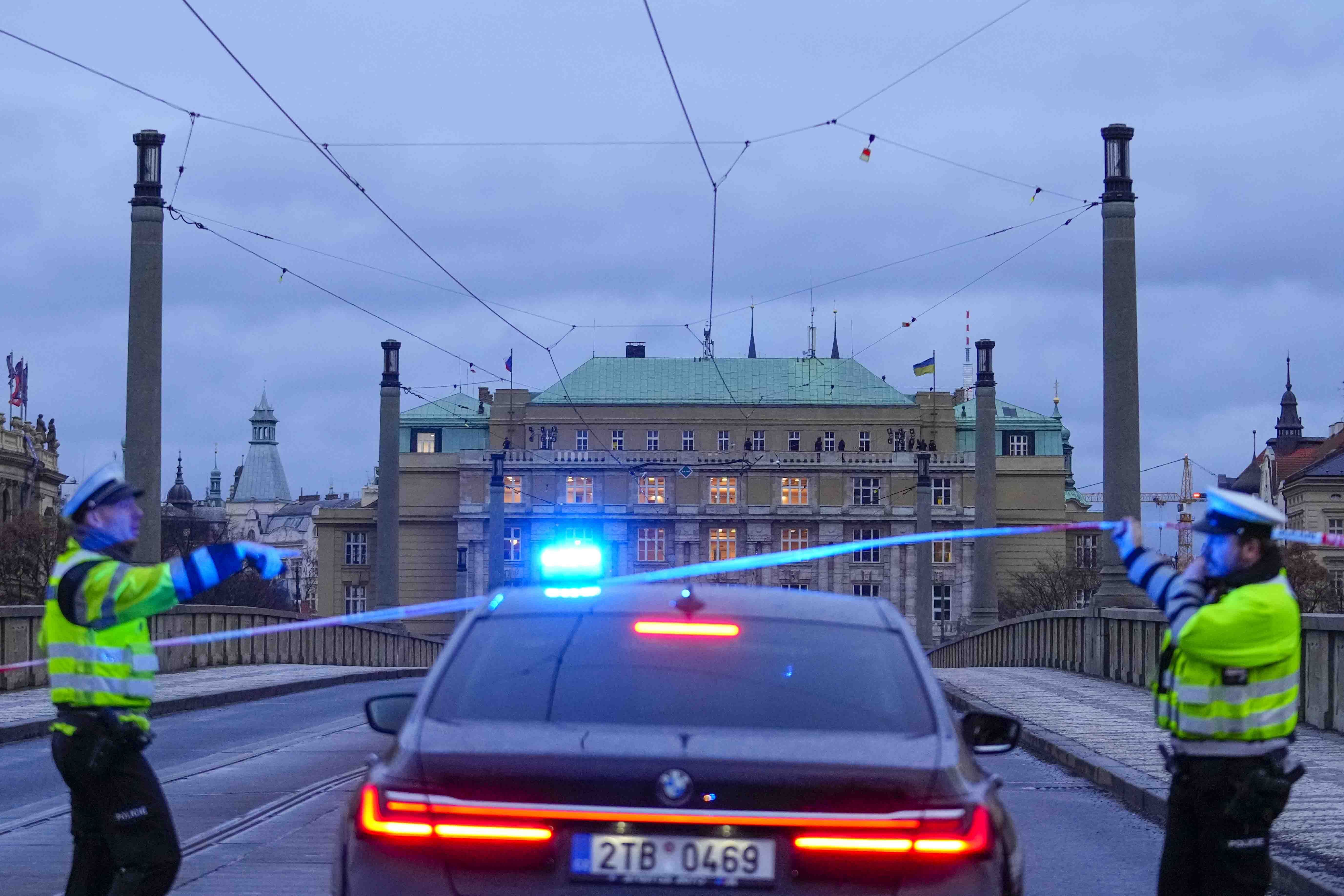 Police officers guard a street in downtown Prague, Czech Republic, Thursday. Czech police say a shooting in downtown Prague has killed 14 people and wounded 25 others.