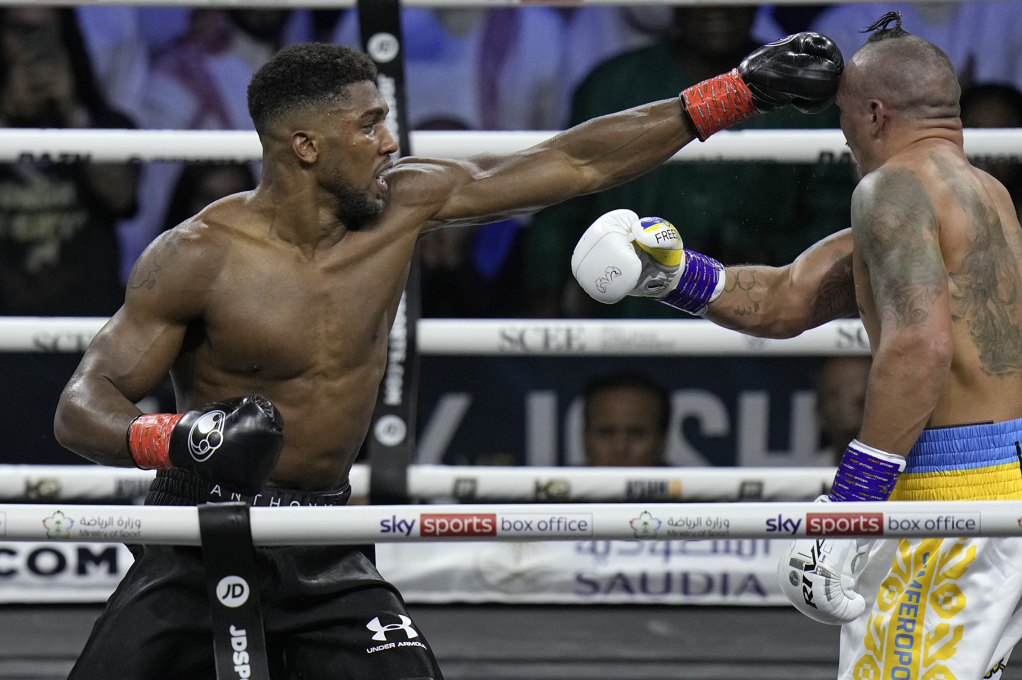 FILE - Britain's Anthony Joshua, right, lands a blow on Ukraine's Oleksandr Usyk during their world heavyweight title fight at King Abdullah Sports City in Jeddah, Saudi Arabia, Sunday, Aug. 21, 2022. Anthony Joshua and Deontay Wilder were once the main characters in heavyweight boxing’s soap opera but now they are extras. Wilder and Joshua are in the kingdom this weekend and fighting simply to stay relevant. 