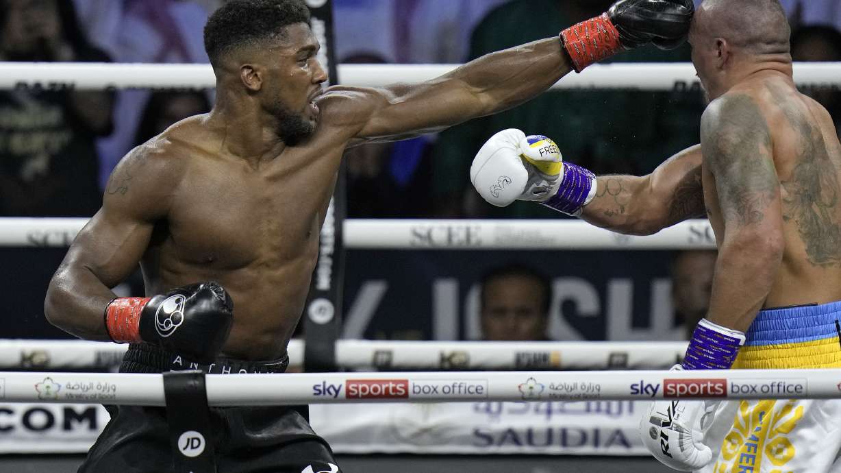 FILE - Britain's Anthony Joshua, right, lands a blow on Ukraine's Oleksandr Usyk during their world heavyweight title fight at King Abdullah Sports City in Jeddah, Saudi Arabia, Sunday, Aug. 21, 2022. Anthony Joshua and Deontay Wilder were once the main characters in heavyweight boxing’s soap opera but now they are extras. Wilder and Joshua are in the kingdom this weekend and fighting simply to stay relevant.