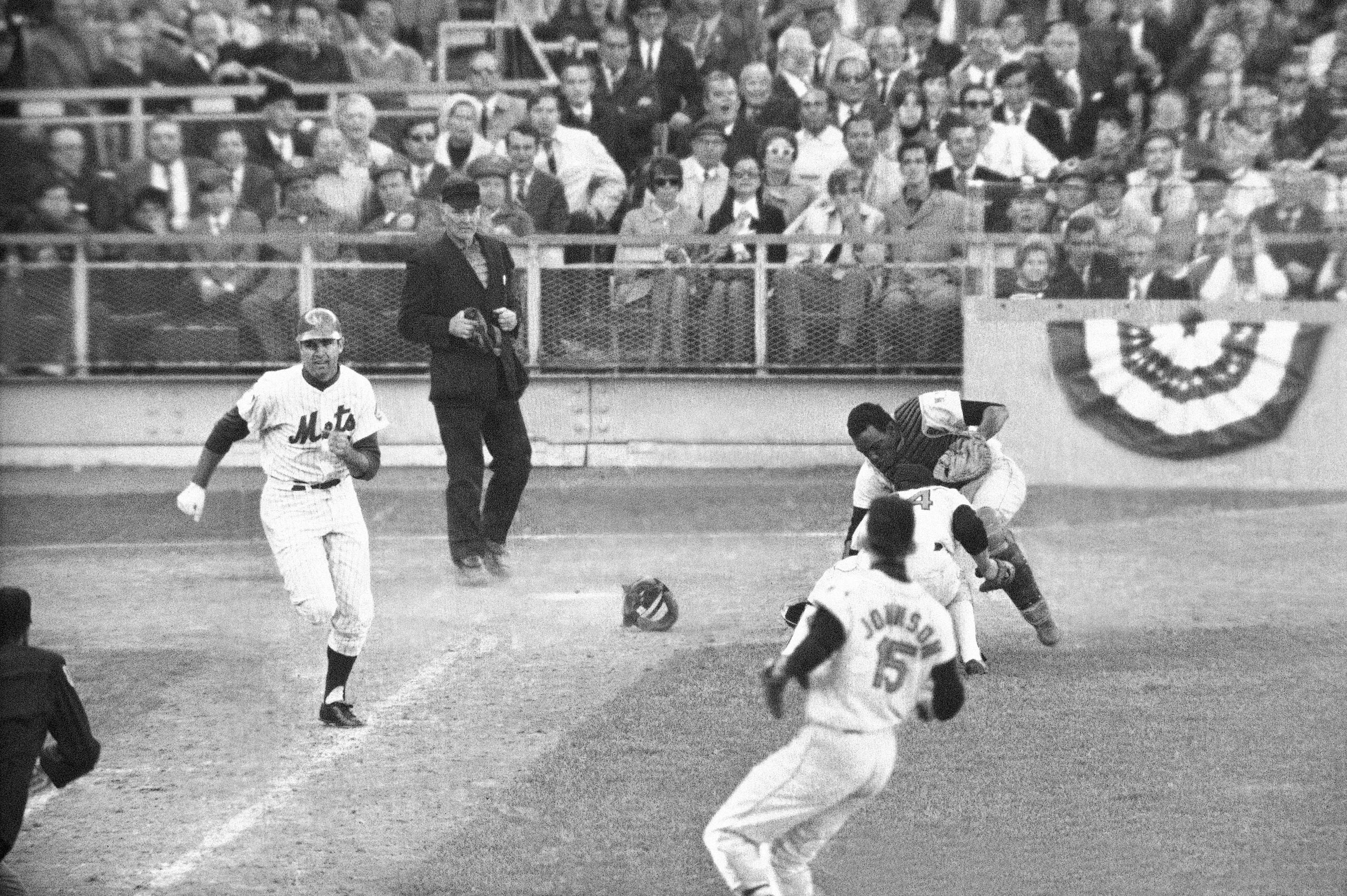 FILE -Orioles catcher Ellie Hendricks and pitcher Pete Richert reach for bunt laid down by J.C. Martin in tenth inning of game 4 of the World Series baseball game Oct. 15, 1969 in New York. Richert fielded it and his throw to Dave Johnson hit Martin in back and bounded away, enabling Rod Gaspar to score from second. Umpire is Shag Crawford. Major League Baseball is widening the runner's lane approaching first base to include a portion of fair territory, shortening the pitcher's clock with runners on base by two seconds to 18 and further reducing mound visits in an effort to further speed games next season.