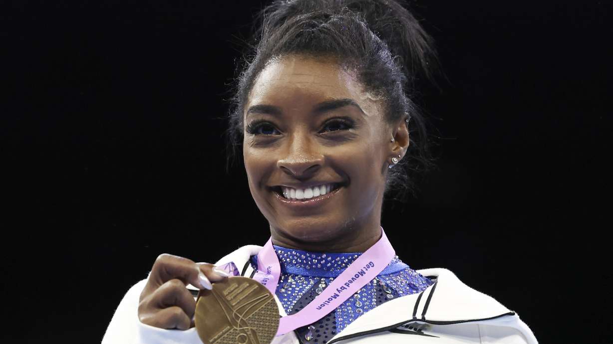 FILE - United States' Simone Biles shows her gold medal after the women's all-round final at the Artistic Gymnastics World Championships in Antwerp, Belgium, Friday, Oct. 6, 2023. Biles was named the AP Female Athlete of the Year for a third time on Friday, Dec. 22, 2023, after winning national and world all-around titles in her return to gymnastics following a two-year break after the Tokyo Olympics.