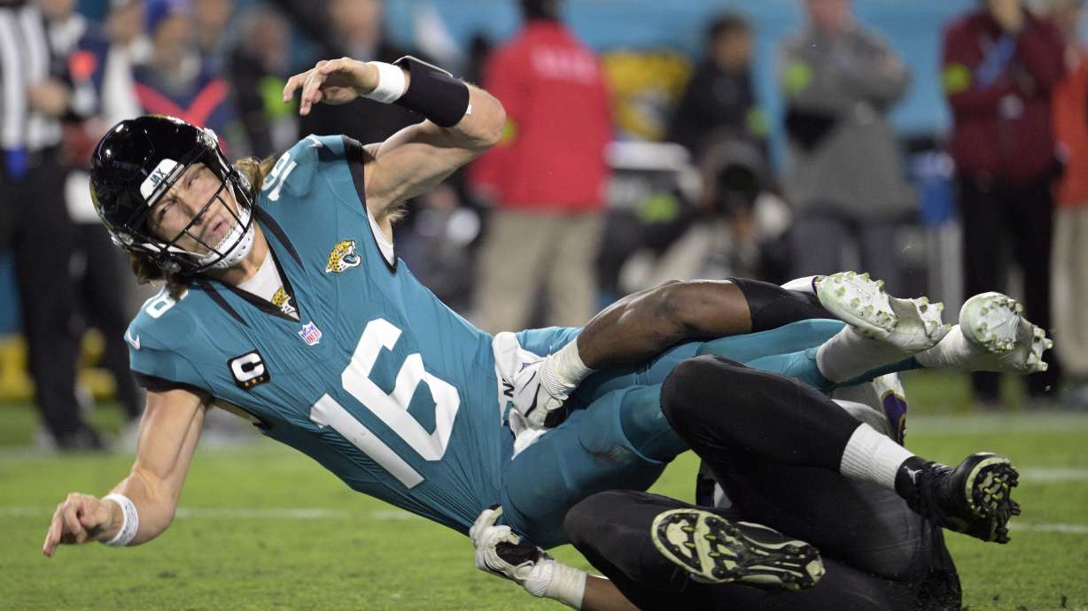 Jacksonville Jaguars quarterback Trevor Lawrence (16) is brought down by Baltimore Ravens defensive tackle Justin Madubuike after Lawrence tried to pass in the second half of an NFL football game Sunday, Dec. 17, 2023, in Jacksonville, Fla.
