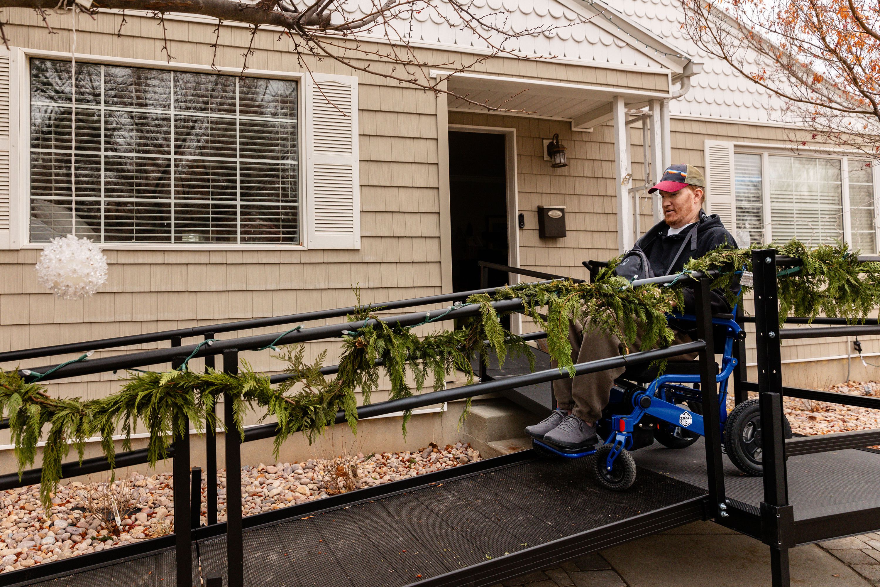 Sean Cunningham takes his wheelchair down the ramp as he prepares to leave for a doctor’s appointment outside his home in Salt Lake City on Dec. 20.