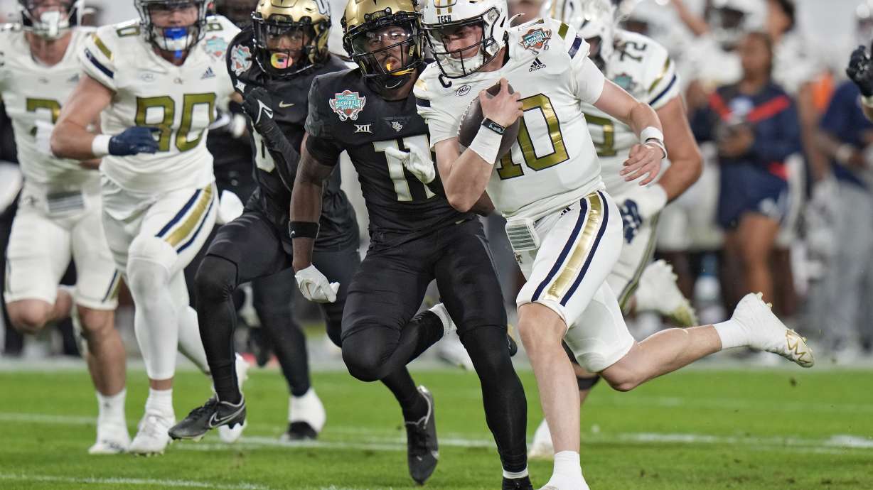 Georgia Tech quarterback Haynes King (10) is stopped by Central Florida defensive back Decorian Patterson (11) on a run during the first half of the Gasparilla Bowl NCAA college football game Friday, Dec. 22, 2023, in Tampa, Fla.