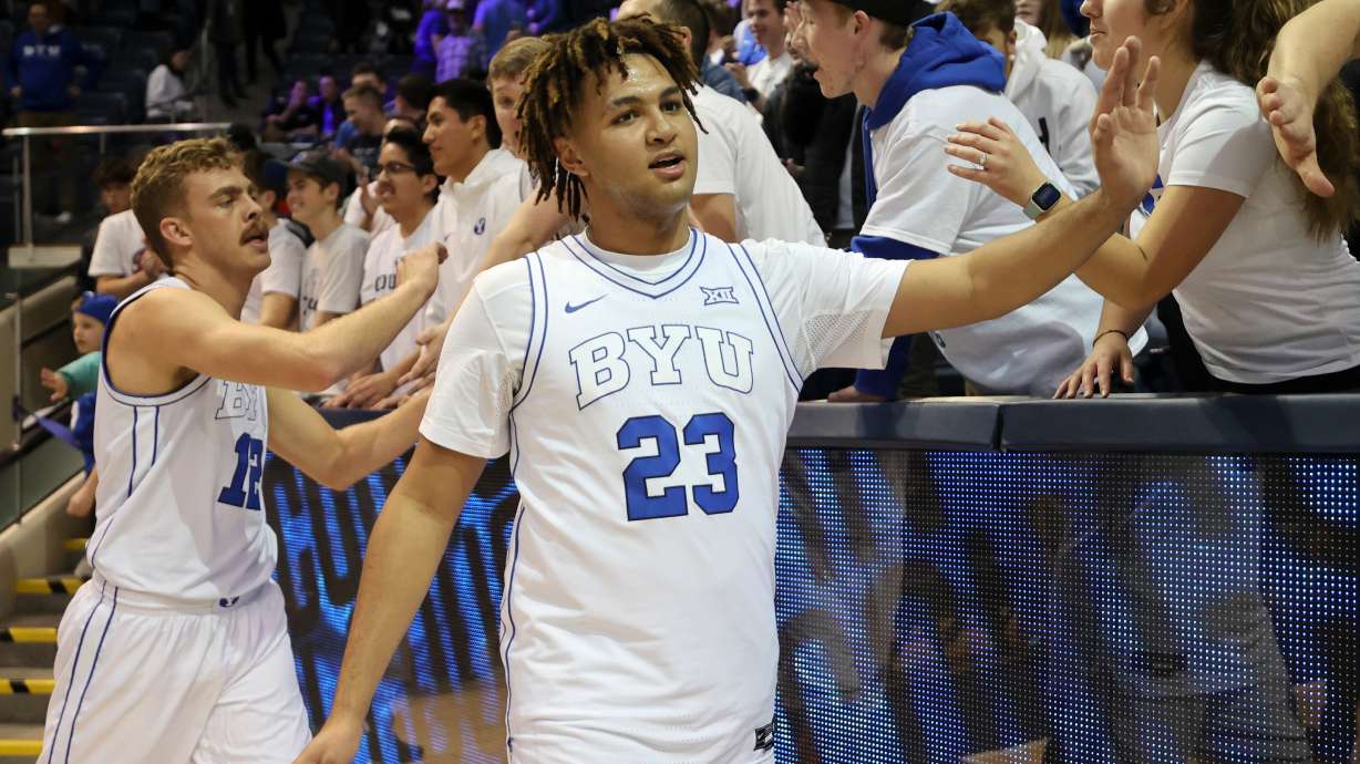 Brigham Young Cougars forward Marcus Adams (23) and Brigham Young Cougars forward Townsend Tripple (12) high-five the front row of the student section after BYU beat Bellarmine in a men’s basketball game at the Marriott Center in Provo on Friday, Dec. 22, 2023. BYU won 101-59.