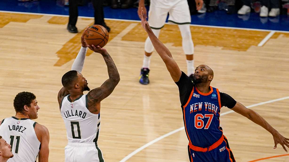 Milwaukee Bucks guard Damian Lillard (0) shoots over New York Knicks forward Taj Gibson (67) during the first half of an NBA basketball game in New York, Saturday, Dec. 23, 2023.