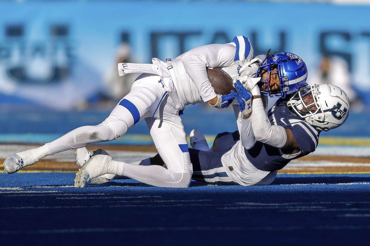 Georgia State wide receiver Cadarrius Thompson, top, is tackled after a reception by Utah State safety Ike Larsen in the first half of the Famous Idaho Potato Bowl NCAA college football game, Saturday, Dec. 23, 2023, in Boise, Idaho.