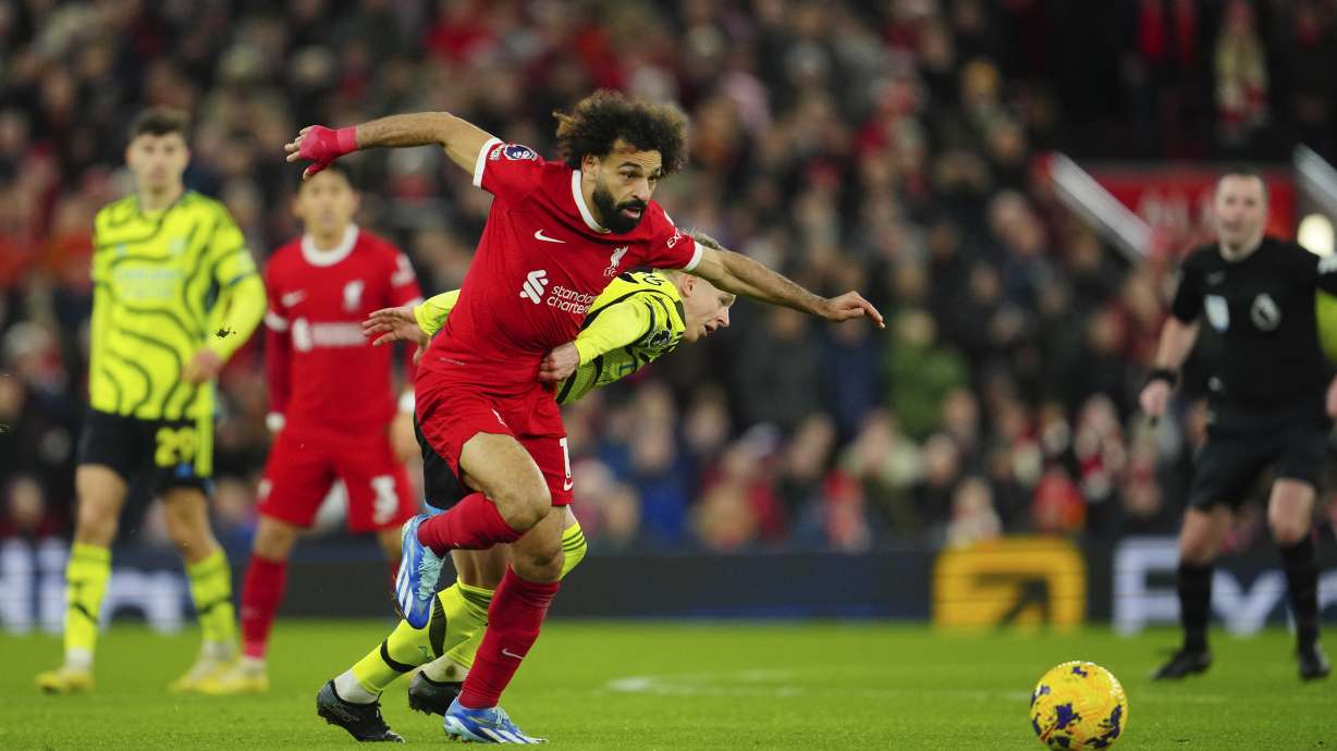 Liverpool's Mohamed Salah, left, and Arsenal's Oleksandr Zinchenko fight for the ball during the English Premier League soccer match between Liverpool and Arsenal at Anfield stadium in Liverpool, England, Saturday, Dec. 23, 2023.