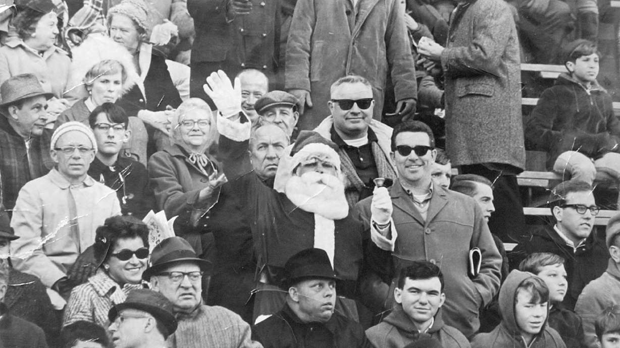 FILE - This 1967 file photo shows Philadelphia Eagles fan Frank Olivo, center, wearing his Santa suit in the stands of a Philadelphia Eagles game in 1967. Olivo, known as the Santa who was booed and dodged snowballs during halftime at a 1968 Eagles game, believes the infamous snowball episode launched the Philadelphia Eagles reputation for boorish fans.