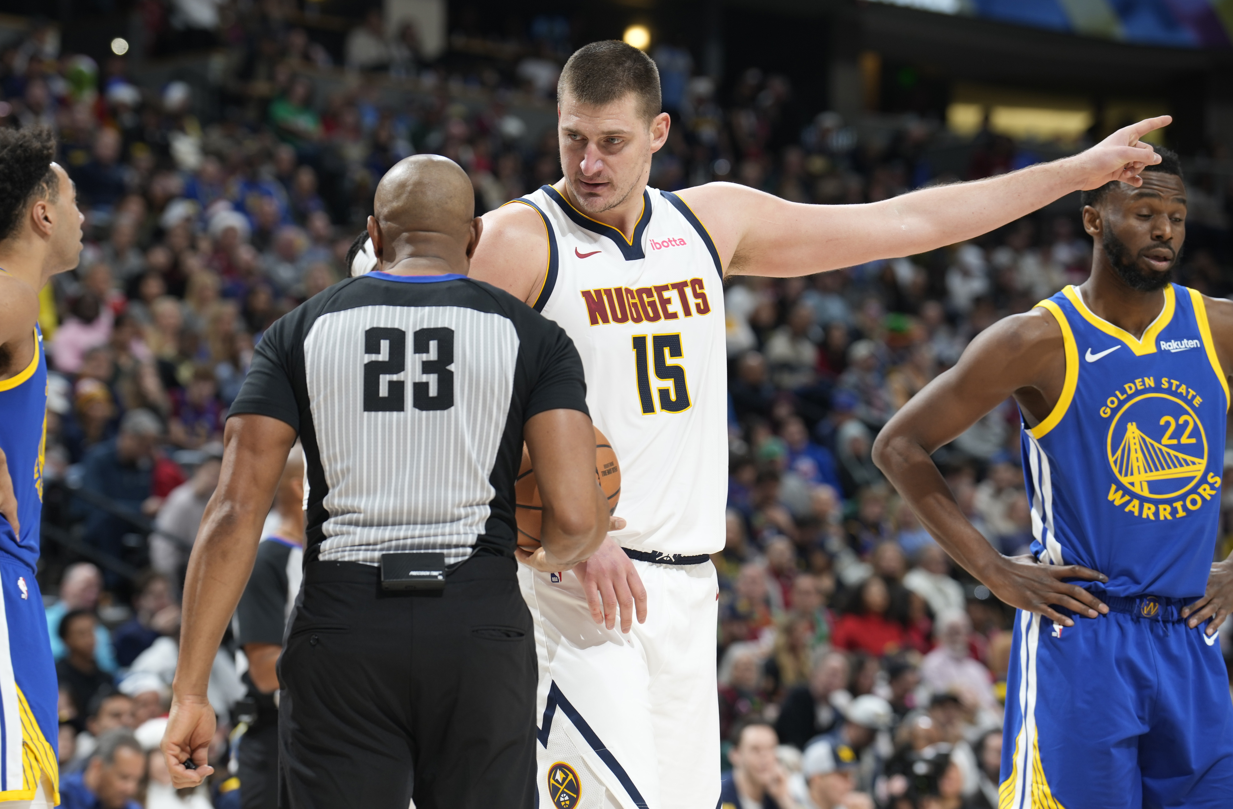 Denver Nuggets center Nikola Jokic, right, argues for a call with referee Tre Maddox in the second half of an NBA basketball game against the Golden State Warriors, Monday, Dec. 25, 2023, in Denver.
