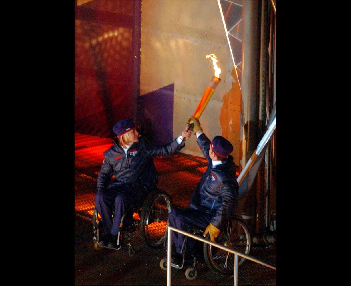 Paralympians Muffy Davis, left, and Chris Waddell, right, light the cauldron during the 2002 Paralympic Opening Ceremony in Salt Lake City, March 7, 2002.