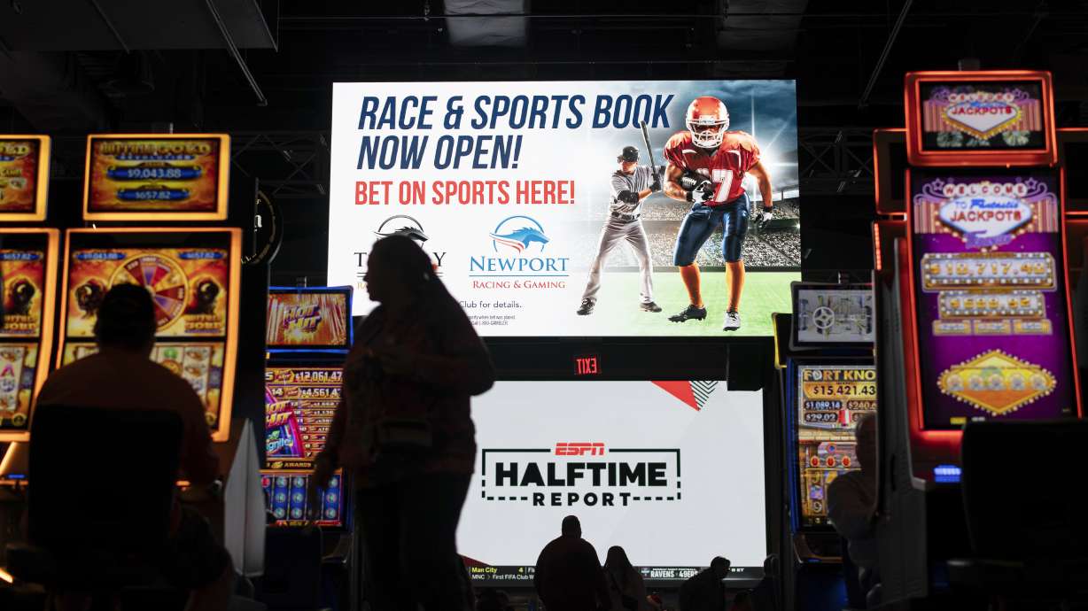 A huge TV screen at the entrance of Churchill's Bourbon & Brew Bar & Grille, flanked by electronic gaming machines, promotes sports betting at Turfway Park Racing & Gaming, Friday, Dec. 22, 2023, in Florence, Ky. Sports betting has spread rapidly across U.S. states in the past five years. But the odds for further expansion may be fading as state legislatures prepare to return to work in 2024.