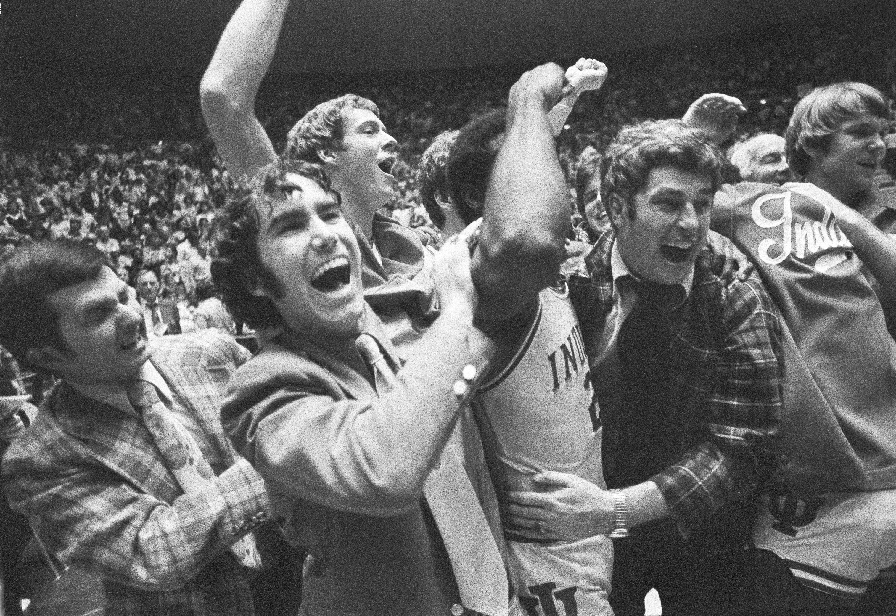 FILE - Indiana coach Bob Knight, right, celebrates with the team and fans after the team's win over Marquette in the NCAA men's college basketball tournament Mideast regionals in Baton Rouge, La., in March 1976. When it was introduced 75 years ago, the purpose of the AP Top 25 men's college basketball poll was to foster discussion and debate. That has not changed.