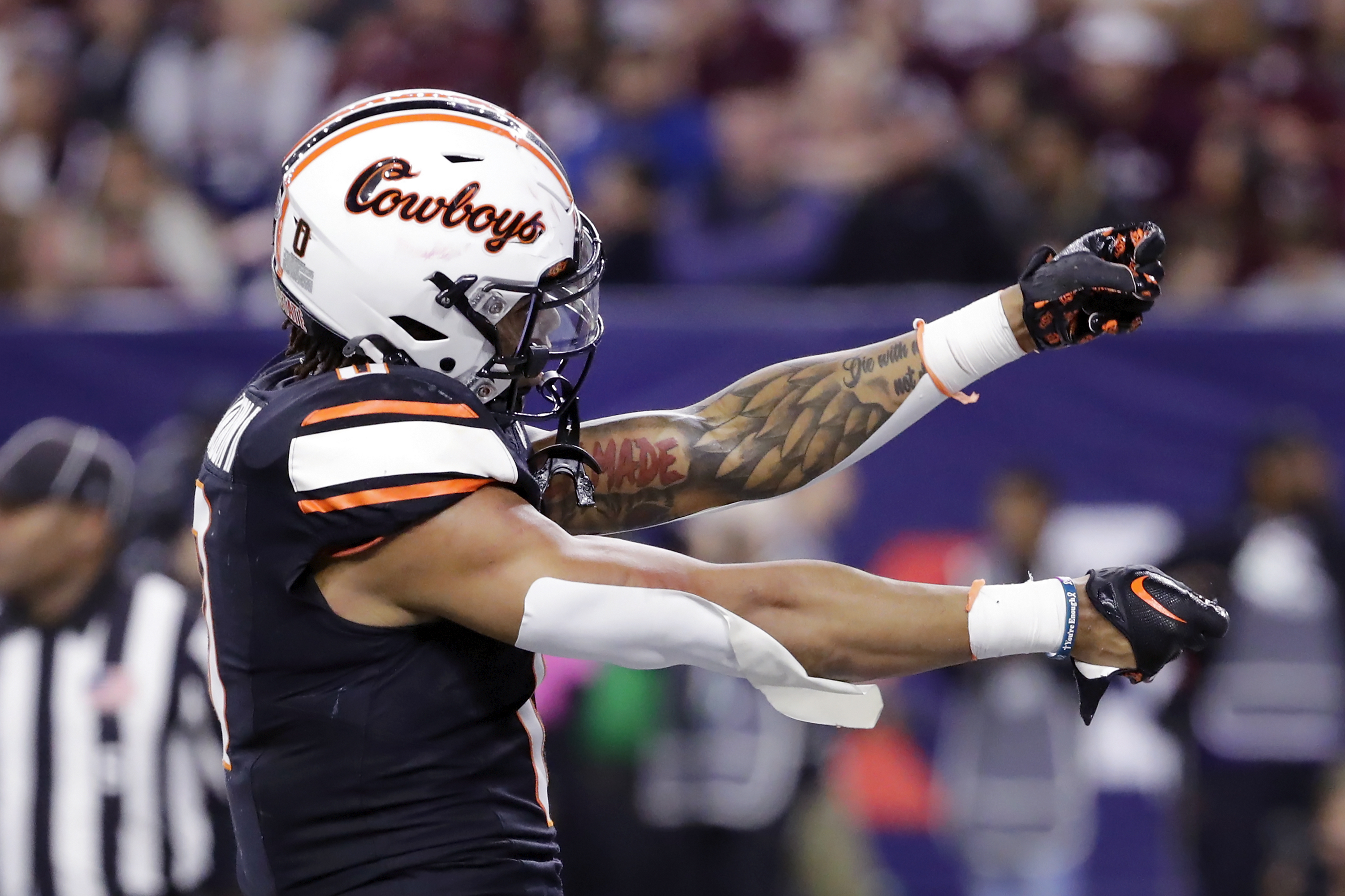 Oklahoma State running back Ollie Gordon II gestures to Texas A&M fans in the stands as he celebrates his touchdown during the first half of the Texas Bowl NCAA football game Wednesday, Dec. 27, 2023, in Houston. 