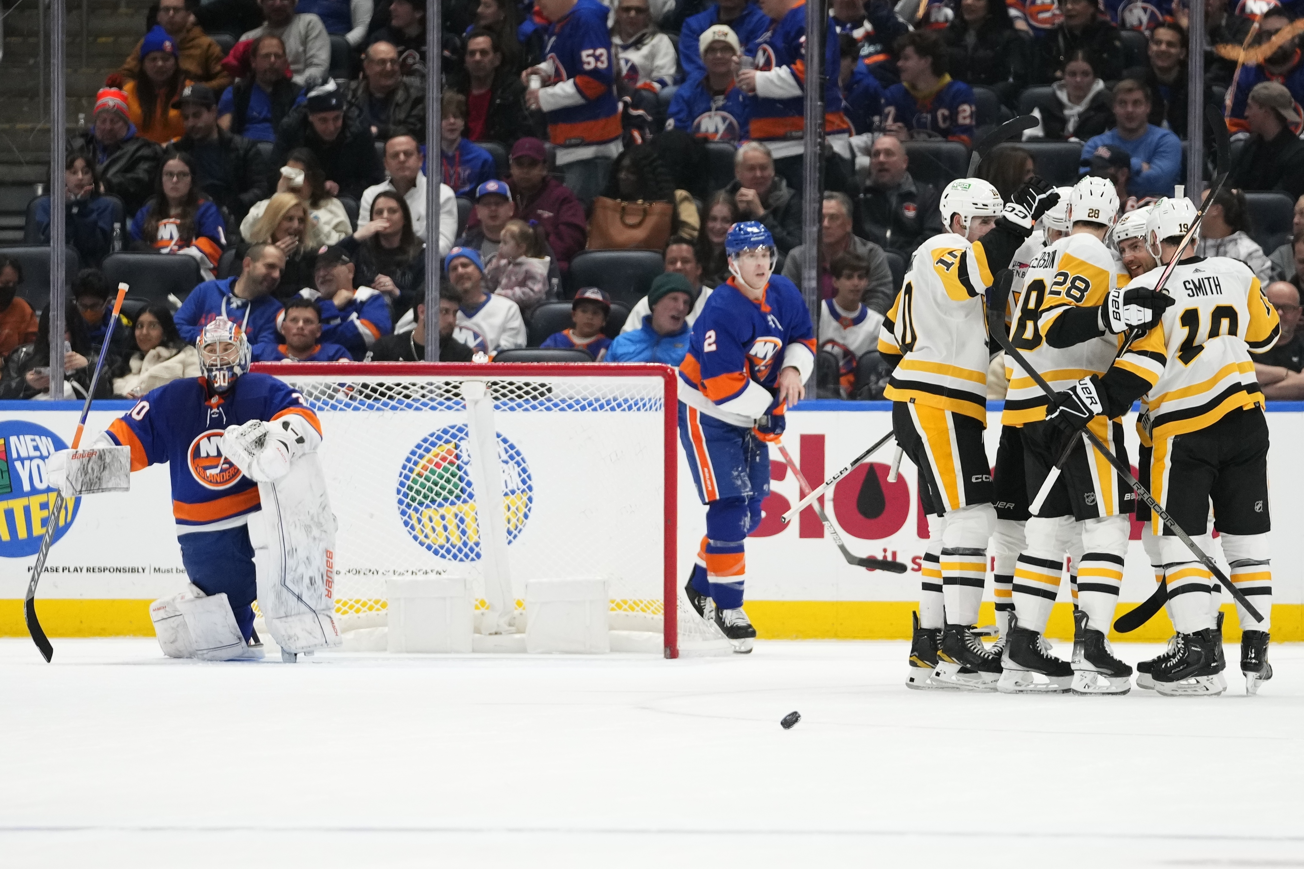 New York Islanders goaltender Ilya Sorokin, left, waits as the Pittsburgh Penguins celebrate a goal by Evgeni Malkin during the second period of an NHL hockey game Wednesday, Dec. 27, 2023, in Elmont, N.Y.