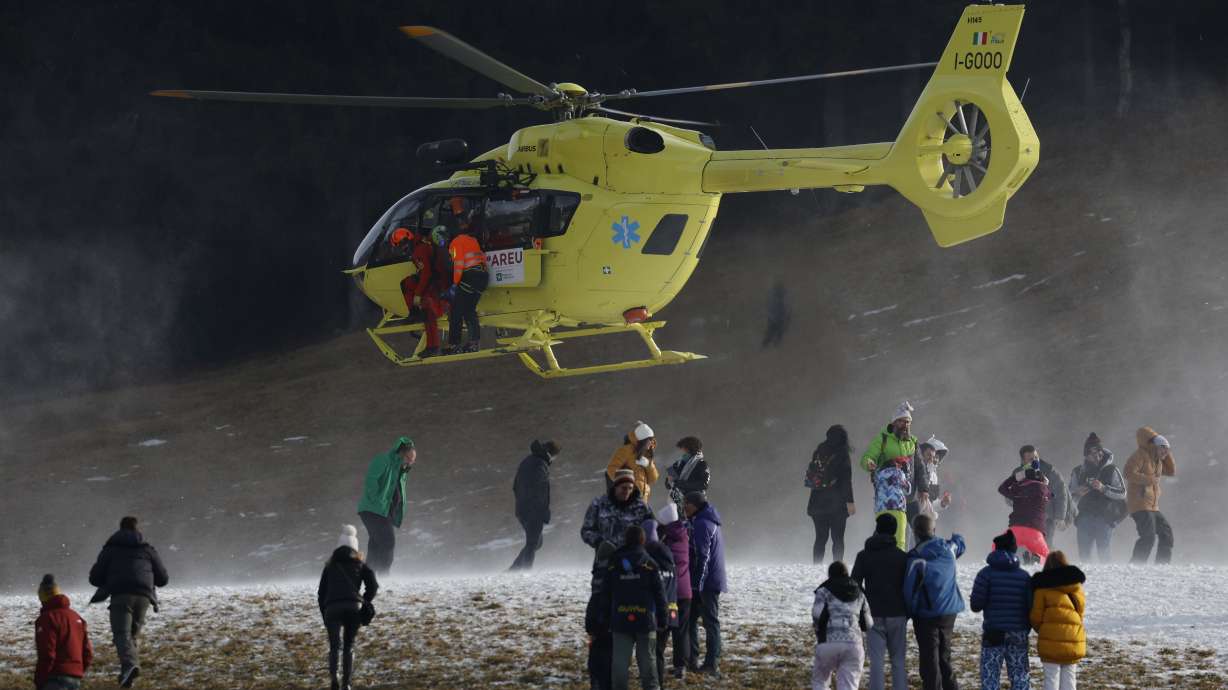 A helicopter carrying Austria's Marco Schwarz, partially seen at center at the helicopter's open door, lands at the finish area after Schwarz crashed during an alpine ski, men's World Cup downhill race, in Bormio, Italy, Thursday, Dec. 28, 2023.