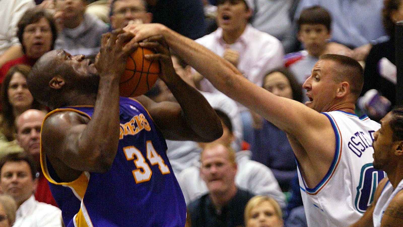 Shaquille O'Neal is tied up by the Jazz's Greg Ostertag as the Lakers and the jazz play in Salt Lake City. Utah March 8, 2004.