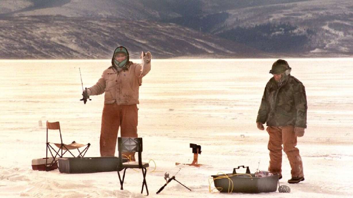 Ken Snow, a happy ice fisherman, holds up a nice 16-inch cutthroat trout on Strawberry Reservoir in 2002.