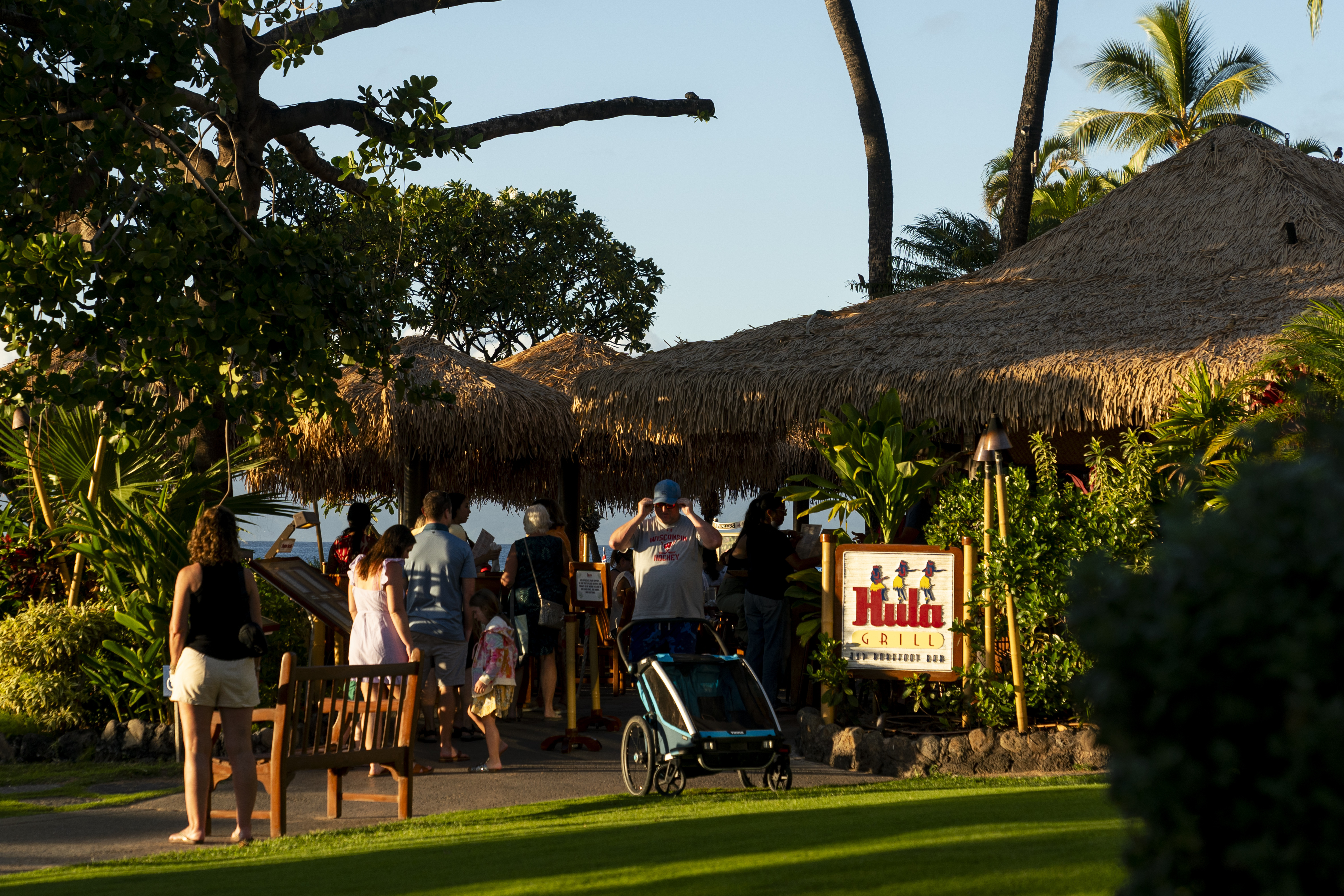 Tourists visit the Hula Grill on Kaanapali Beach, Dec. 6, in Lahaina, Hawaii. Residents and survivors still dealing with the aftermath of the August wildfires in Lahaina have mixed feelings as tourists begin to return to the west side of Maui.