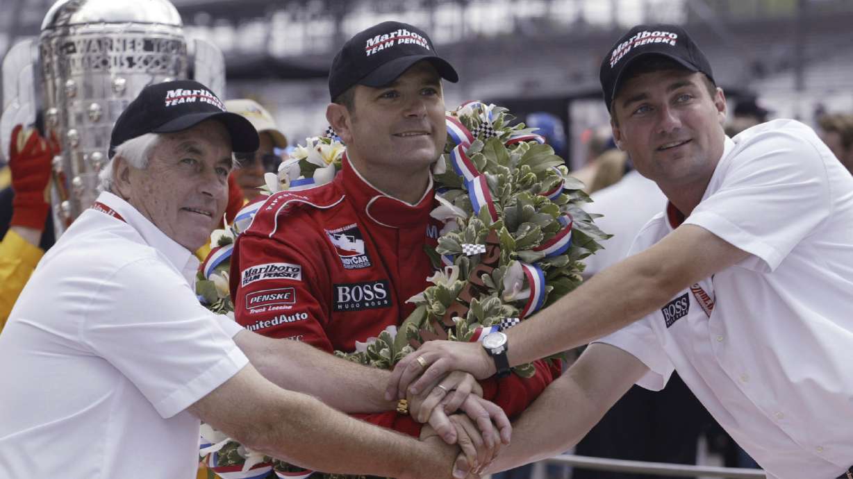 FILE - Car owner Roger Penske, left, and Tim Cindric, right, president of Penske Racing, clasp hands with Indianapolis 500 winner Gil de Ferran, of Brazil, on May 25, 2003, in Indianapolis. De Ferran, winner of the 2003 Indy 500 and holder of the closed-course land speed record, died Friday, Dec. 29, 2023, while racing with his son at The Concourse Club in Florida, multiple former colleagues confirmed to The Associated Press. He was 56.