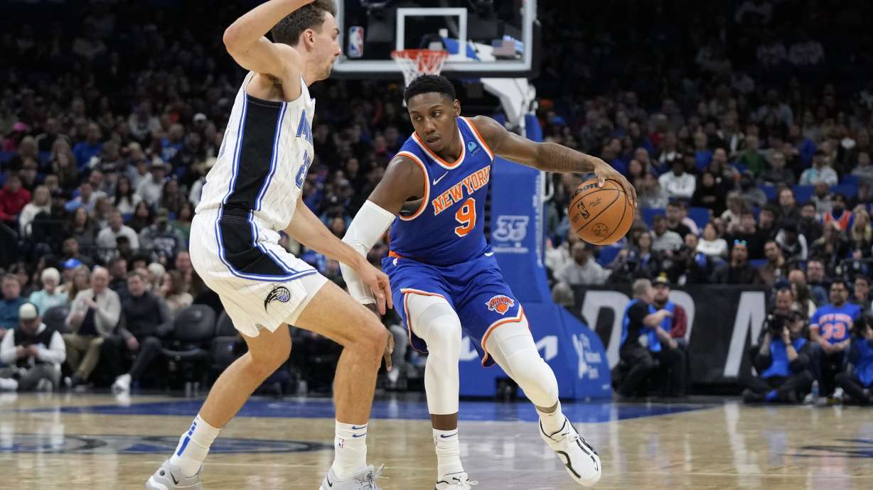 New York Knicks guard RJ Barrett (9) looks for a way around Orlando Magic forward Franz Wagner, left, during the first half of an NBA basketball game, Friday, Dec. 29, 2023, in Orlando, Fla.