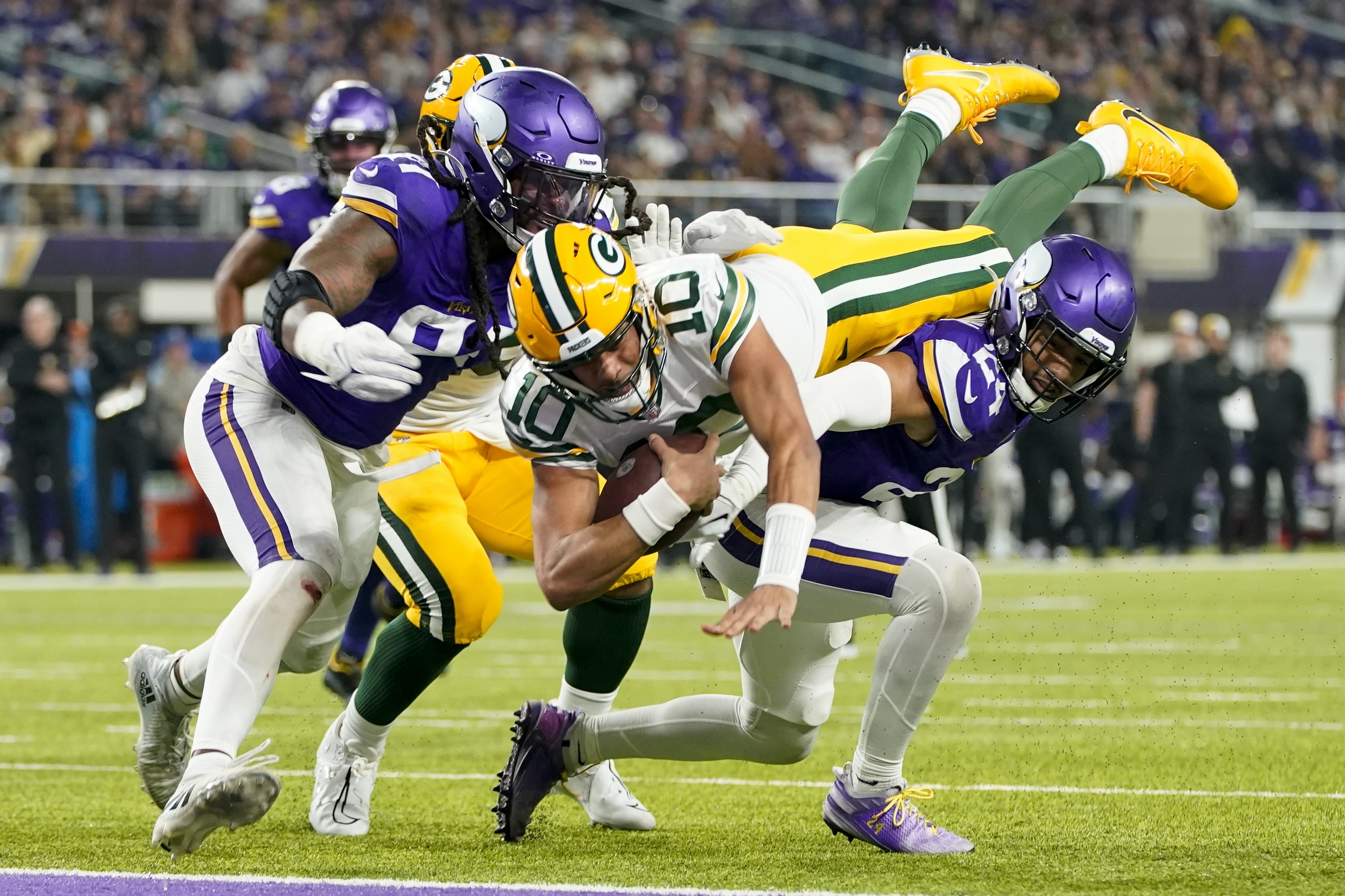 Green Bay Packers' Jordan Love dives into the end zone for a touchdown during the first half of an NFL football game against the Minnesota Vikings Sunday, Dec. 31, 2023, in Minneapolis. 