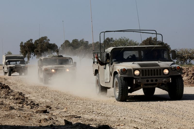 Israeli military vehicles move near the Israel-Gaza border, amid the ongoing conflict between Israel and the Palestinian Islamist group Hamas, in southern Israel, on Sunday. Israel is withdrawing some forces from Gaza to shift to more targeted operations against Hamas.