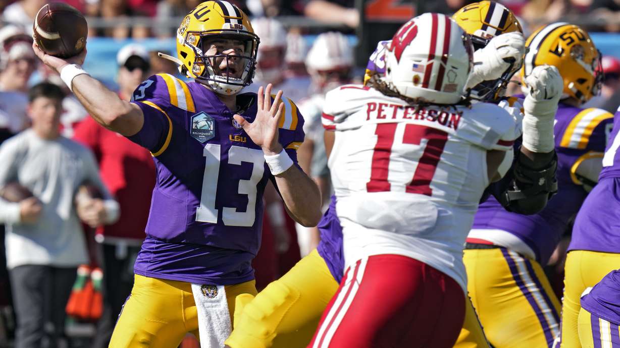 LSU quarterback Garrett Nussmeier (13) throws a pass as he is pressured by Wisconsin linebacker Darryl Peterson during the first half of the ReliaQuest Bowl NCAA college football game Monday, Jan. 1, 2024, in Tampa, Fla.