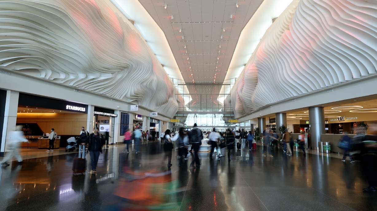 People move through Salt Lake City International Airport in Salt Lake City on Oct. 31. A 30-year-old man was found dead inside an airplane's engine there Monday night.