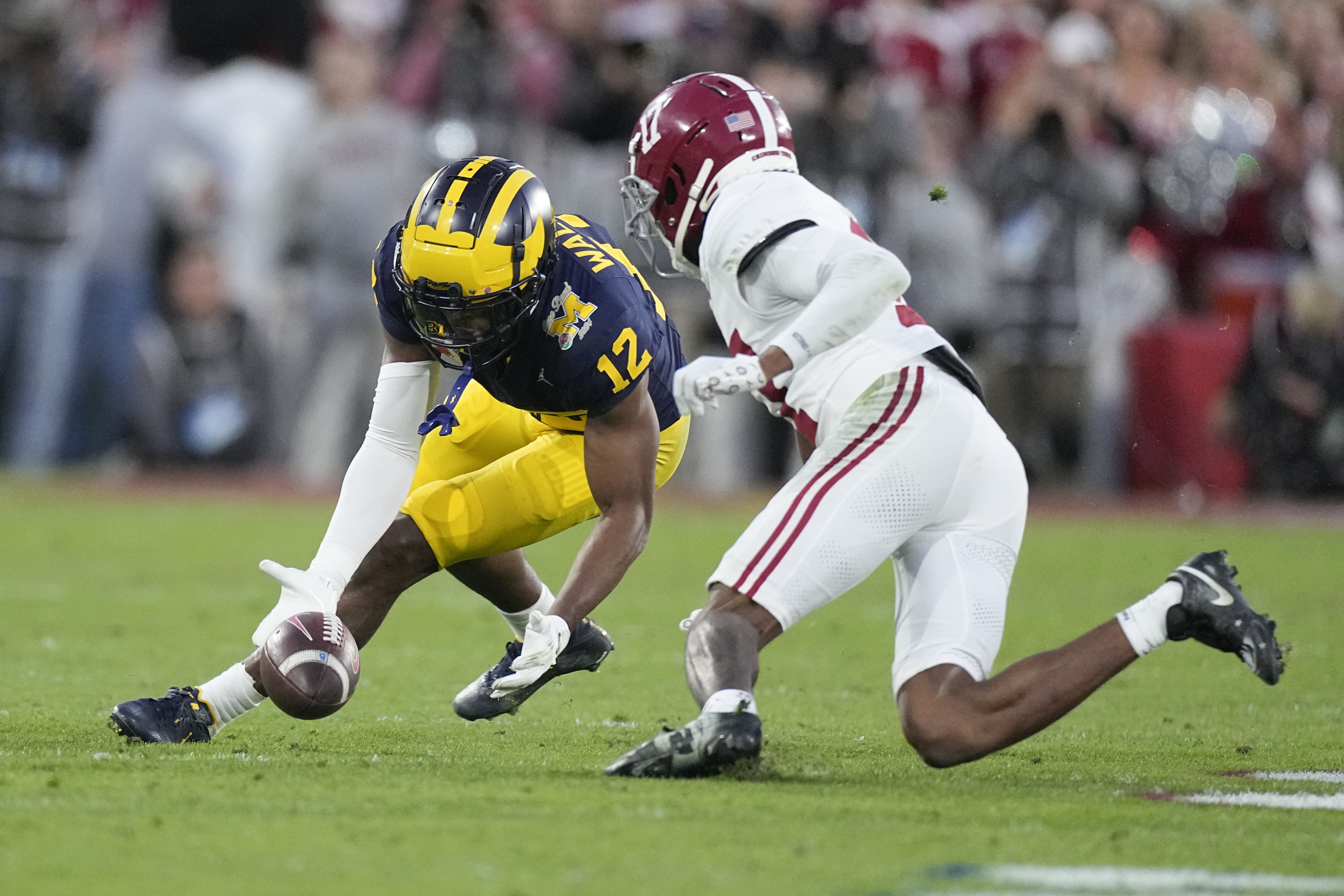 Michigan defensive back Josh Wallace (12) recovers a fumble by Alabama quarterback Jalen Milroe (4) during the second half in the Rose Bowl CFP NCAA semifinal college football game Monday, Jan. 1, 2024, in Pasadena, Calif.