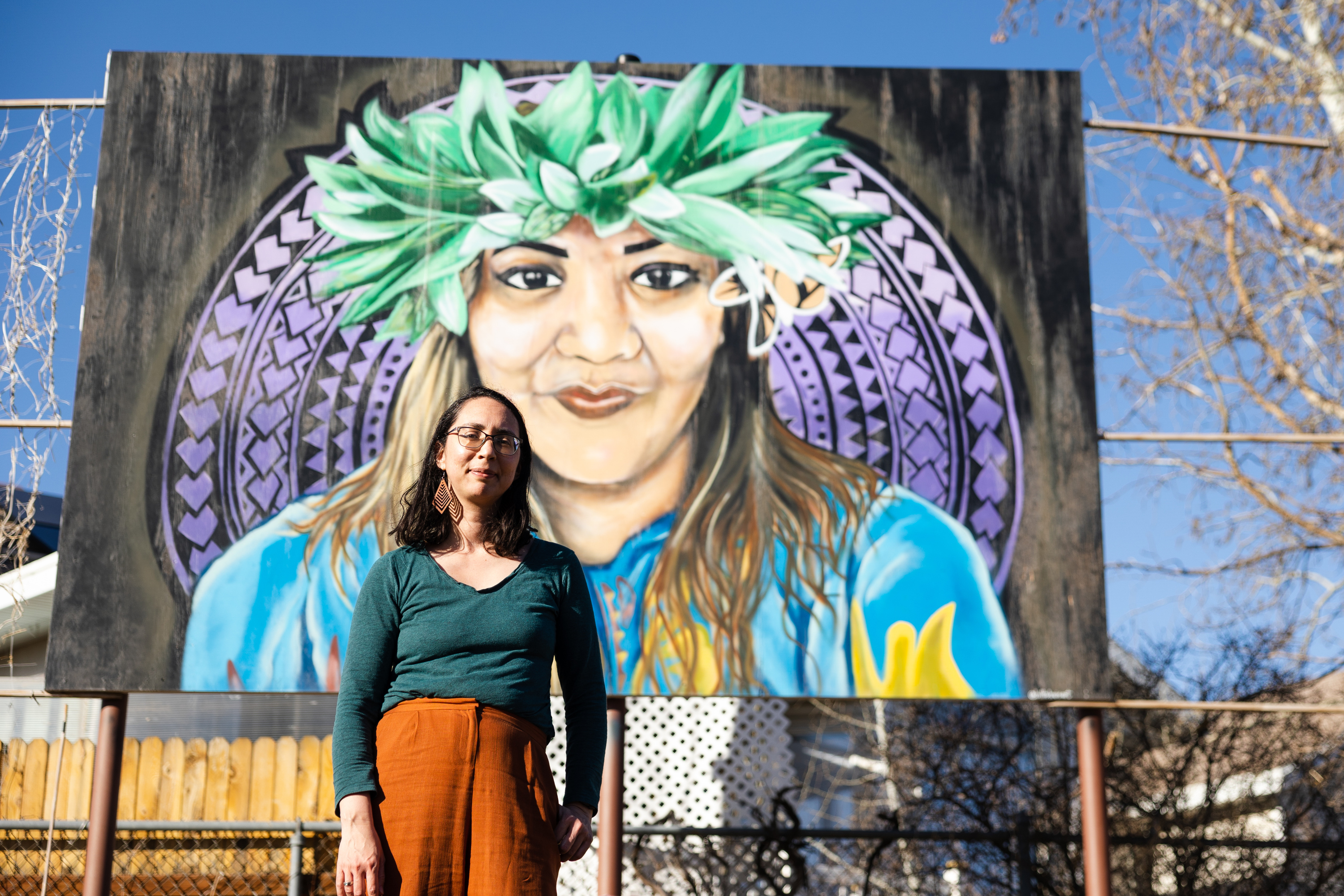 Maile Arvin, a garden volunteer and University of Utah professor, poses for a portrait in front of a mural dedicated to Margarita Satini at the Og-Woi People's Garden in Salt Lake City on April 10, 2023. The mural is one of many public art pieces across the city.