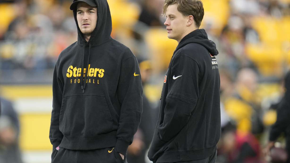Pittsburgh Steelers quarterback Kenny Pickett, left, and Cincinnati Bengals quarterback Joe Burrow watch warmups together before the start of an NFL football game, Saturday, Dec. 23, 2023, in Pittsburgh.