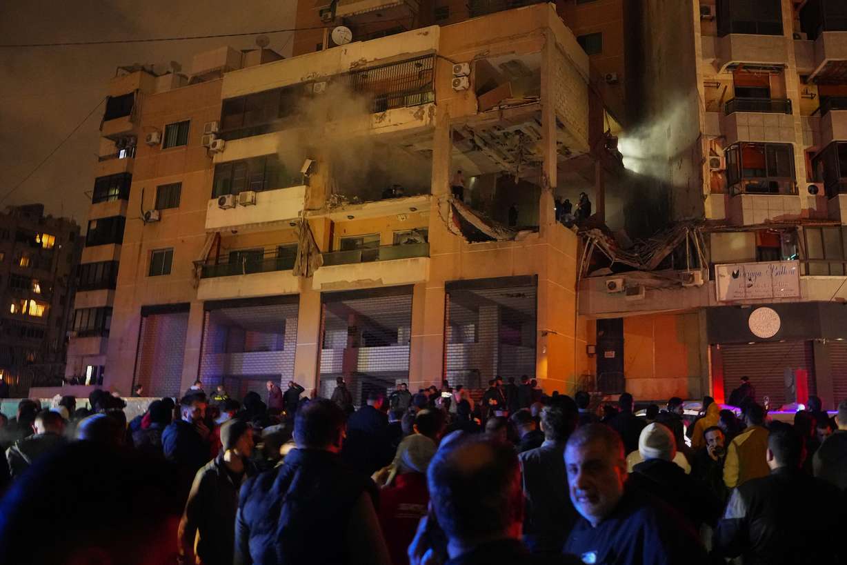 People gather outside a damaged building following a massive explosion in the southern Beirut suburb of Dahiyeh, Lebanon, Tuesday. The TV station of Lebanon's Hezbollah group says top Hamas official Saleh Arouri was killed Tuesday in an explosion in a southern Beirut suburb.