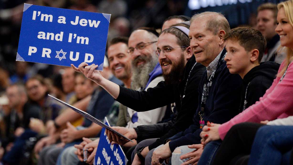 Rabbi Avremi Zippel holds up a sign that say’s “I’m a Jew and I’m Proud” during the NBA basketball game between the Utah Jazz and the Dallas Mavericks at the Delta Center in Salt Lake City on Monday, Jan. 1, 2024.
