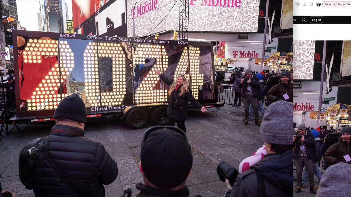 People pose in front of the 2024 New Year's Eve numerals displayed in Times Square on December 20, in New York.