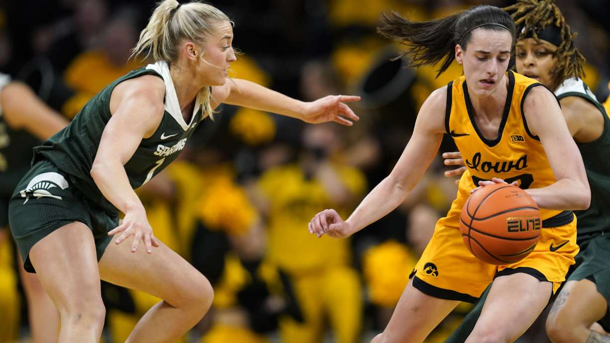 Iowa guard Caitlin Clark (22) drives past Michigan State guard Tory Ozment (1) during the first half of an NCAA college basketball game, Tuesday, Jan. 2, 2024, in Iowa City, Iowa.