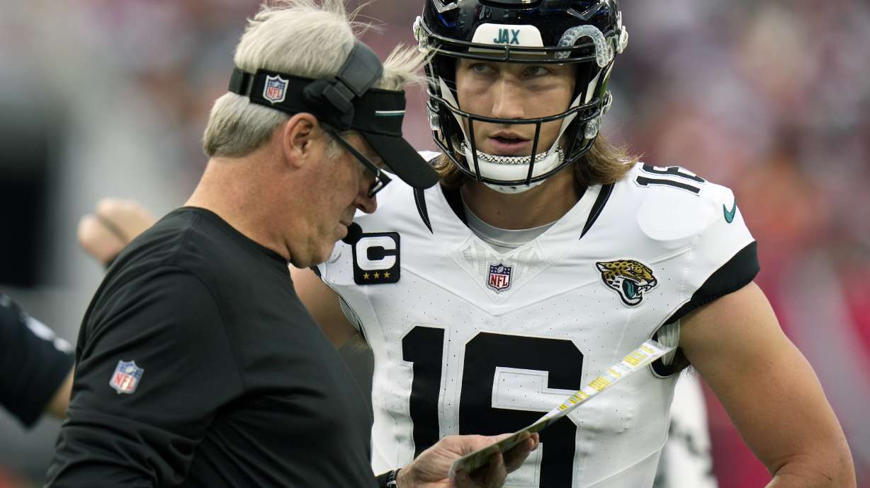 Jacksonville Jaguars head coach Doug Pederson meets with quarterback Trevor Lawrence (16) on the sideline during the first half of an NFL football game against the Tampa Bay Buccaneers, Sunday, Dec. 24, 2023, in Tampa, Fla.